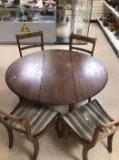A MAHOGANY EXTENDING DINING TABLE WITH FOUR CHAIRS