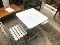 A FOLDING METAL WHITE TABLE AND TWO CHAIRS