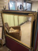 A LARGE GILDED BEVELLED EDGED MIRROR WITH A WOODEN GILDED AND EBONISED FRAME 119 X 93CM