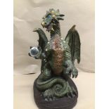 A LARGE RESIN MYTHICAL DRAGON HOLDING A CRYSTAL BALL 50CMS