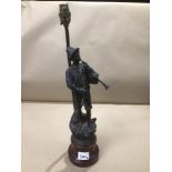 A LAMP WITH A SPELTER FIGURE PLAYING BAGPIPES ON A WOODEN BASE 50CMS