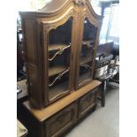 A TWO PIECE ITALIAN DISPLAY CUPBOARD WITH ORNATE DETAILING