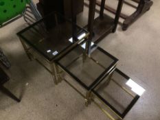 A 1960'S BRASS AND SMOKE GLASS NEST OF TABLES