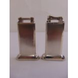 Two Dunhill rectangular engine turned table lighters on raised oval bases