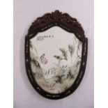 A Chinese hand painted porcelain plaque in hardwood shield shape frame with bone inlays