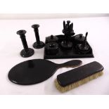 An ebony dressing table set to include a ring stand, candlesticks, covered boxes and a tray