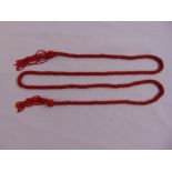 A coral bead necklace with tassel knot ends, approx length 138cm, approx total weight 78.7 grams