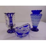 A blue overlaid glass lustre, a blue overlaid cut glass baluster vase and a blue overlaid cut