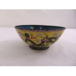 A Chinese enamelled dish decorated with dragons and stylised clouds against a yellow ground, marks