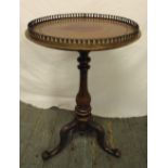 A Victorian circular side table with pierced metal gallery, on three outswept legs