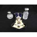 A silver cased egg cup, spoon and napkin ring and two cut glass dressing table bottles with silver