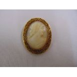 A carved cameo brooch of a classical profile set in an 18ct yellow gold filigree frame