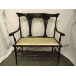 A Victorian mahogany two seater settle with scrolling arms, pierced slats on four tapering