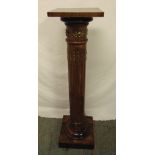 A mahogany torchere of columnular form with applied gilt metal mounts on raised rectangular base