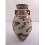 A Chinese Ming style baluster vase with dragon side handles and stylised clouds and vegetation to
