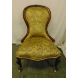 A Victorian mahogany upholstered balloon back chair on scroll legs with original castors