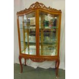An Epstein bow fronted rectangular glazed display cabinet with scroll pierced top on cabriole legs