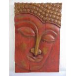 An Oriental rectangular relief carved image of a stylised face, 91 x 60.5cm