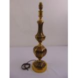 A panelled baluster form brass table lamp on raised hexagonal base and circular plinth
