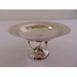 A silver hand hammered arts and crafts bonbon dish, the circular bowl on three pierced scroll