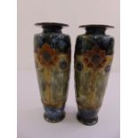 A pair of Royal Doulton relief moulded stoneware vases with floral and beaded decoration on a