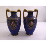 A pair of Noritake vases circular form decorated with floral panels and gilded scroll handles, marks