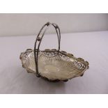 A silver oval roll basket fluted with leaf engraved scroll pierced sides, bifurcated swing handle on
