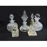 Five cut glass perfume bottles of various shape, all with drop stoppers, two with silver collars
