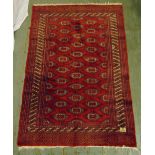 A Middle Eastern wool carpet red ground with repeating geometric forms and stylised border, 179 x
