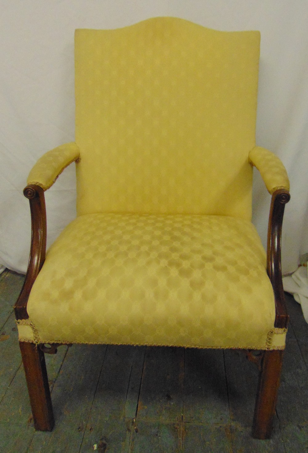 A mahogany high back upholstered armchair on four rectangular legs