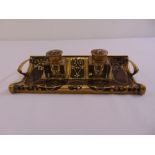 An Art Nouveau rectangular brass and wooden ink stand supporting two glass inkwells