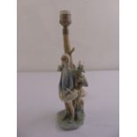 A Lladro table lamp figural group on naturalistic base
