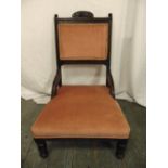 An Edwardian mahogany upholstered nursing chair on turned cylindrical legs
