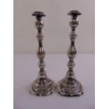 A pair of silver table candlesticks, leaf engraved knopped stems on shaped rectangular bases, London