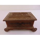 An Anglo Indian rectangular heavily chased and carved jewellery casket on four bird supports, A/F