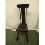 A Victorian oak milking chair with T-form geometric back, carved seat and cylindrical legs