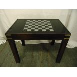 A 1960s mahogany rectangular games table the glass sliding top opening to reveal a compendium of