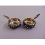 A matched pair of Russian white metal and cloisonne‚ salts of circular form with condiment spoons