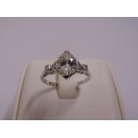 Platinum and diamond ring flanked by diamonds to the shoulders, the central diamond approx 1ct