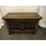 A rectangular oak blanket box with hinged cover and linen fold panels on bracket feet