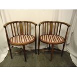 A pair of Edwardian oval inlaid mahogany occasional chairs on tapering cylindrical legs