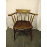 An elm Windsor chair of customary form with turned spindles on four turned legs
