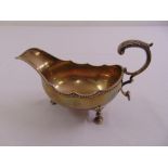 An Irish silver sauce boat oval, gadrooned border with double scroll handle on shell mounted pad