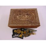 A rectangular carved wooden jewellery box to include a quantity of WWII badges