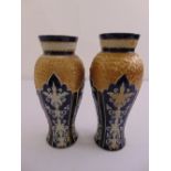 A pair of Doulton vases of baluster form decorated with stylised leaves and scrolls