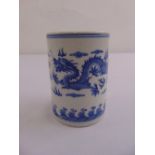 A Chinese blue and white cylindrical brush pot decorated with an image of a dragon