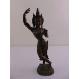 A far eastern cast brass figurine of a female dancer on raised oval base with lotus leaf border,