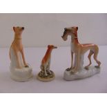 Three Staffordshire porcelain figurines of long dogs on naturalistic bases