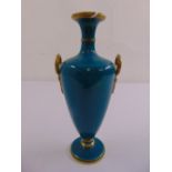 A continental turquoise glazed porcelain baluster vase with gilded side handles and borders