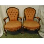 A pair of Victorian mahogany upholstered armchairs on cabriole legs